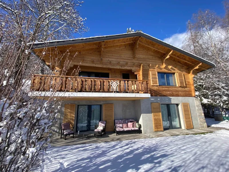 The wooden exterior of Chalet Cervo with its balcony, in the snow