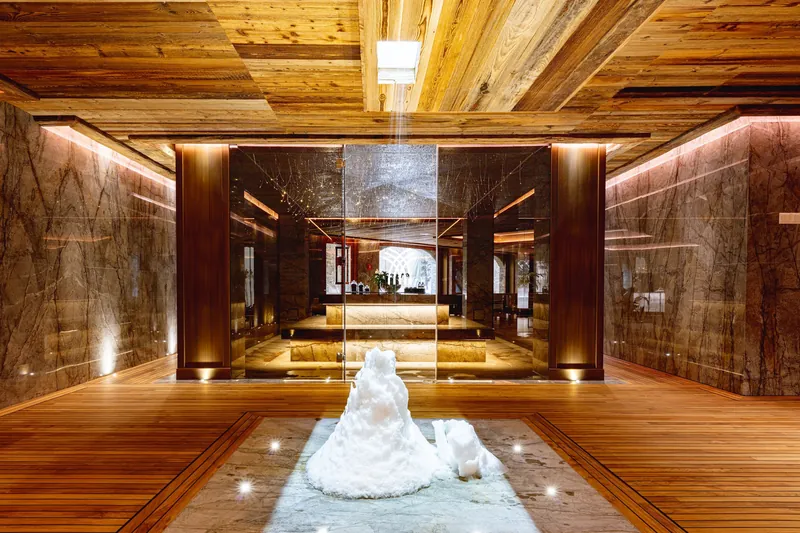 The lit wood-and-stone wellness corridor of Chalet Christiana