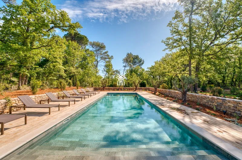 The long pool and loungers of Hameau Font under the oaks of Provence
