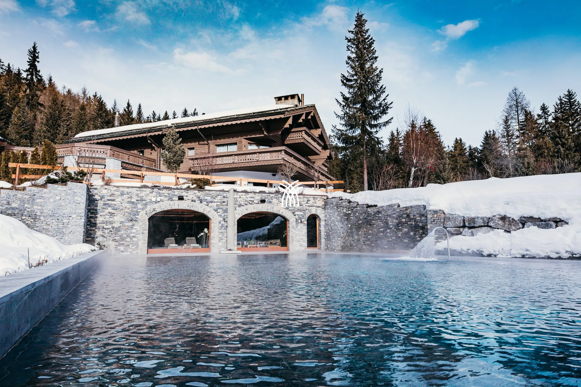 The heated outdoor pool of Chalet Christiana in Crans-Montana, under snow